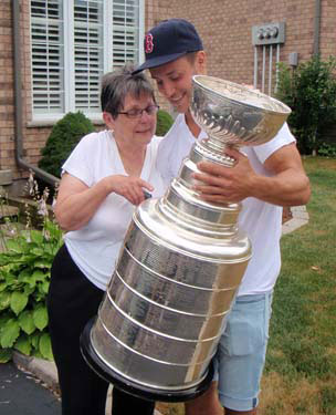Gregory Campbell and his former Kitchener billet Ann Slipec looking over the names engraved on the Stanley Cup.